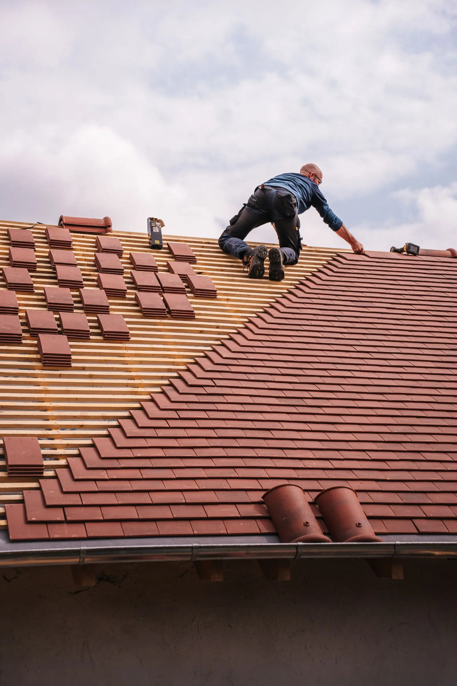 Dachdecker arbeitet konzentriert an der Eindeckung eines Wohnhausdachs